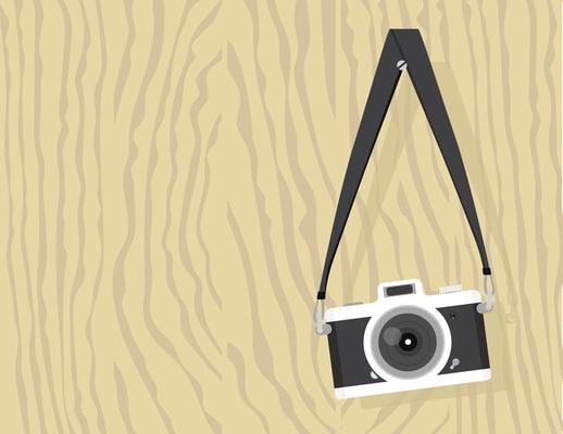 vintage camera hanging on a screw on a wood board
