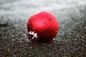 Christmas ornament with droplets of water on the black sand photo