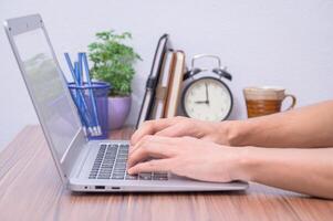 Hands of a person using a laptop computer photo