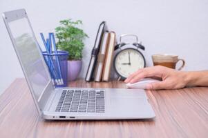 A person using a laptop computer on a desk photo