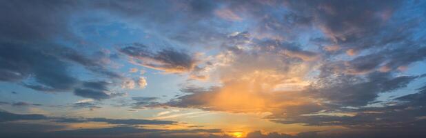 A sunset over the ocean with clouds and sun photo