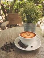 una taza de café con leche en una cafetería con un tono de color vintage foto