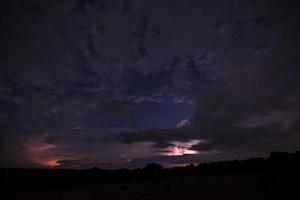 Lightning bolt and clouds at night photo
