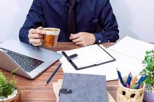 Businessman drinking coffee at his desk photo