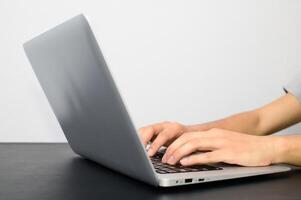 A person typing on a laptop computer photo