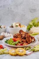 Fried chicken legs with tomato, chili, fried onion, lettuce, corn and mushroom photo