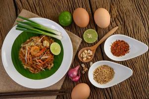 pad thai camarones en un bol con huevos, cebolleta y condimentos foto