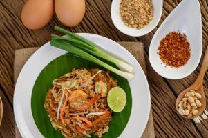 Plate of pad thai shrimp with lime and eggs photo
