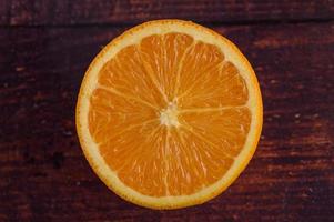 Imagen macro de una naranja madura sobre fondo de madera foto
