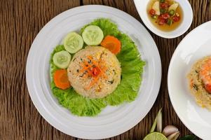 Fried rice on a white plate with lettuce and garnish photo