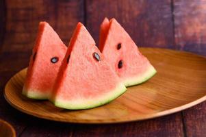 Watermelon cut into pieces on a wooden table photo