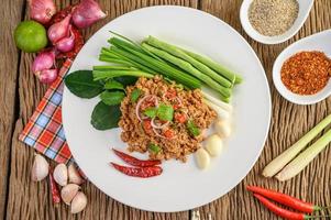 Ensalada de cerdo picada con especias sobre una mesa de madera foto