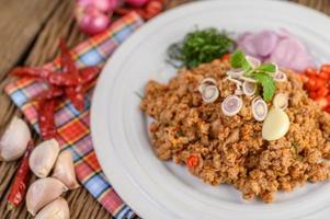 Minced pork salad with spices on a wooden table photo