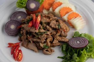 Stir-fried pork basil with carrots, cucumber and onion photo