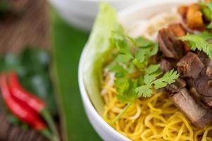 fideos amarillos con crujiente de cerdo y albóndigas foto