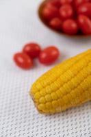 Tomatoes and corn on a white cloth photo