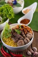 Yellow noodles with crispy pork and meatballs photo