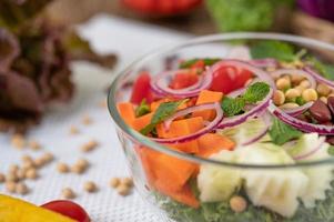 Ensalada de frutas y verduras en un tazón de vidrio.