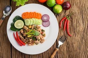 Minced pork salad with spices on a wooden table photo