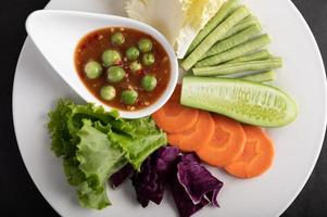 Sauce in a bowl with vegetables photo