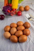 Eggs on a white cloth with vegetables photo