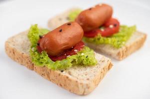 Sausage with tomatoes and salad on bread photo