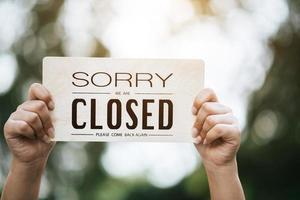 Girl holding a closed sign photo