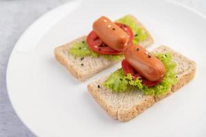 Sausage with tomatoes and salad on bread photo