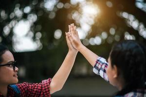 Two young college students giving high fives to each other photo