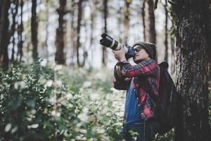 Young photographer taking photos in the forest