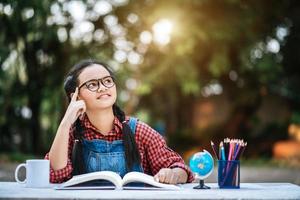 Young girl reading and thinking outdoors photo