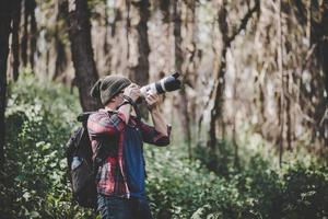 Young photographer taking photos in the forest