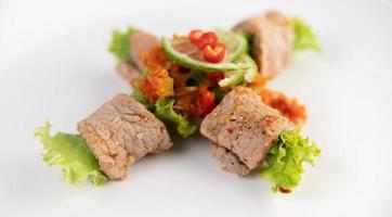 Spicy pork salad with galangal, lemon, chili and garlic photo