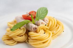 Plated spaghetti and pork arranged on a white plate photo