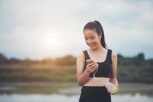 Adolescente fitness con auriculares escuchando música durante su entrenamiento foto