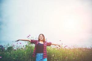 Happy young woman raising her hands in a meadow photo