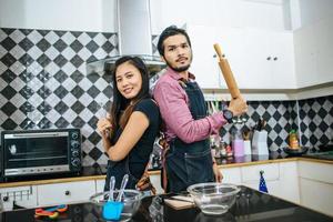 Atractiva pareja cocinando en la cocina de casa foto