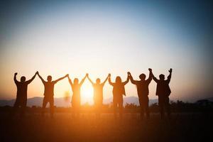 Silhouette of happy team making high hands photo