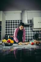 Cute little girl kneads flour dough in the kitchen photo