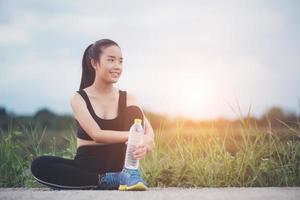 Teen fitness runner relaxing with water after training photo