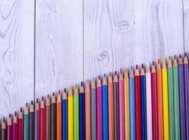 lápices de madera de colores, dispuestos en forma de escalera, sobre un fondo gris y blanco. concepto de educación. foto