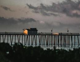 Muelle de madera marrón sobre el cuerpo de agua durante la noche foto