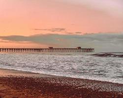 Sea waves crashing on shore during sunset photo