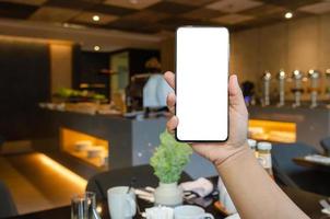 usando un teléfono móvil en la mesa de la cena foto