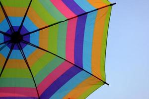 Rainbow umbrella on sky background photo