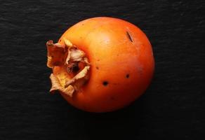 Persimmon on black photo