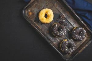 Colorful donuts on Black table. Top view photo