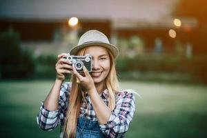mujer joven posa con cámara de película retro foto