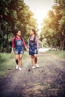 Two young girls walking along a forest road photo