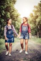 Two young girls walking along a forest road photo